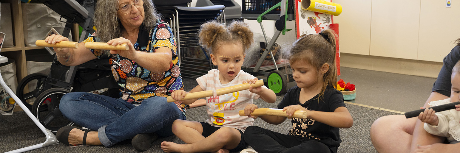 Parents and children sitting on the floor singing together