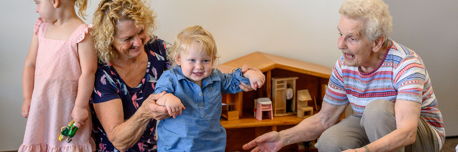 A grandparent, parent and child playing together